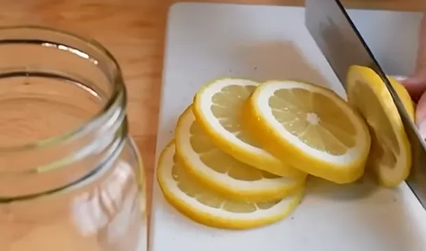 Et lyst bord med en citron og et glas citronvand, der illustrerer citron- og citronvandtemaet.