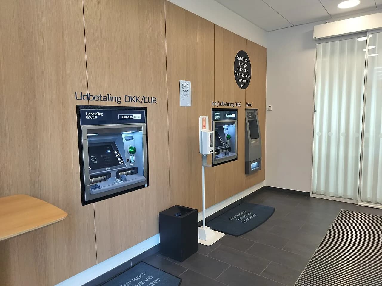 Indgang og lobbyområde ved en Danske Bank-ATM i Kolding, Danmark. Billedet viser bankens faciliteter i et bymiljø.
