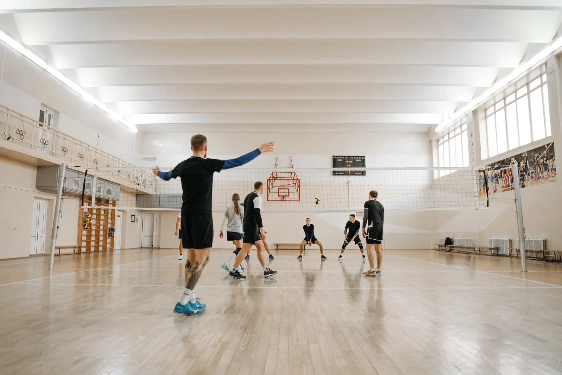 En energisk volleyballtræningssession med en blandet hold indendørs. Perfekt til sportsrelaterede temaer.