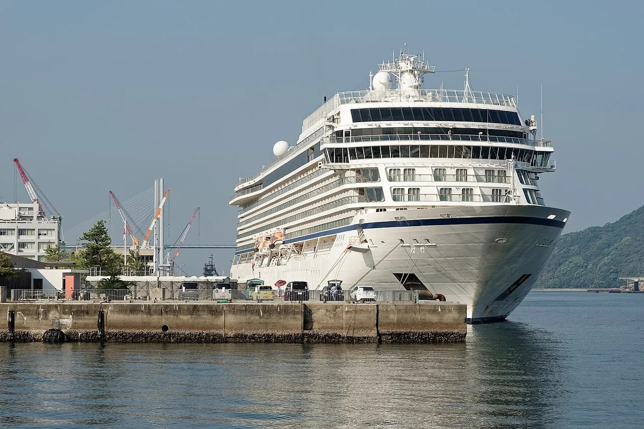 Et krydstogtskib ligger til kaj i havnen i Nagasaki. Billedet viser skibet i byens havnemiljø.