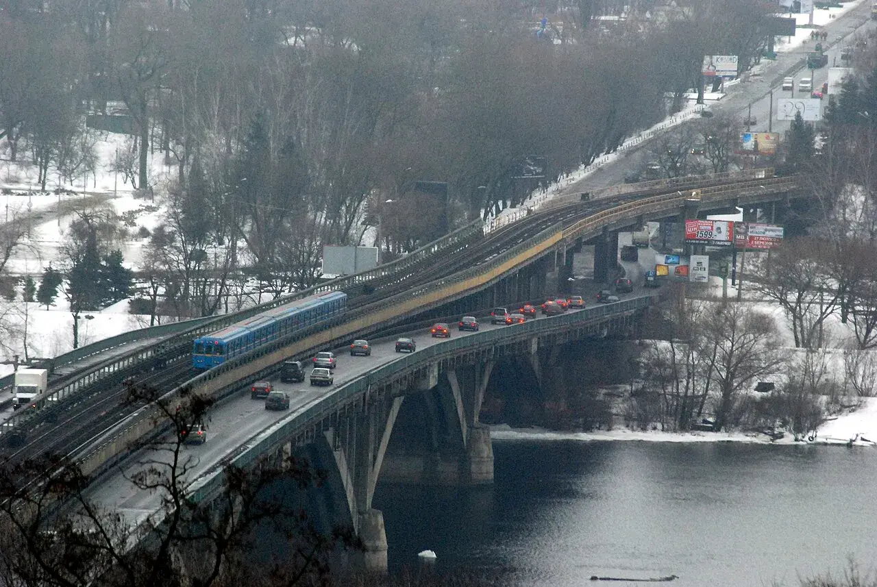 Et metro-tog krydser Dnipro via Metrobroen i Kyiv. Billedet er taget fra området ved Kiev-Pechersk Lavra.