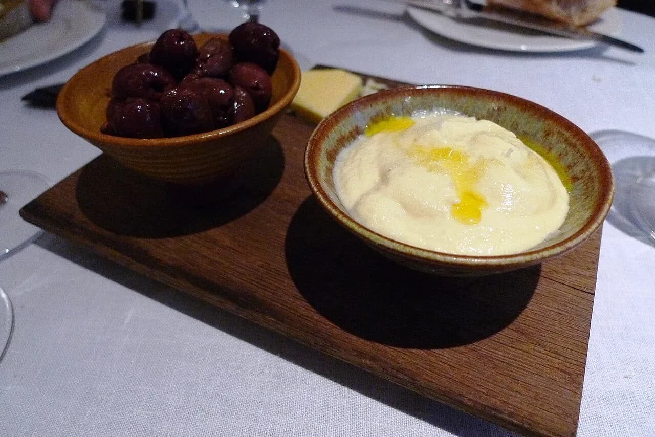 Oliven og saltet torsk-brandade serveret sammen med brød. Billedet viser en klassisk retkombination fra Pollen Street Social i London.