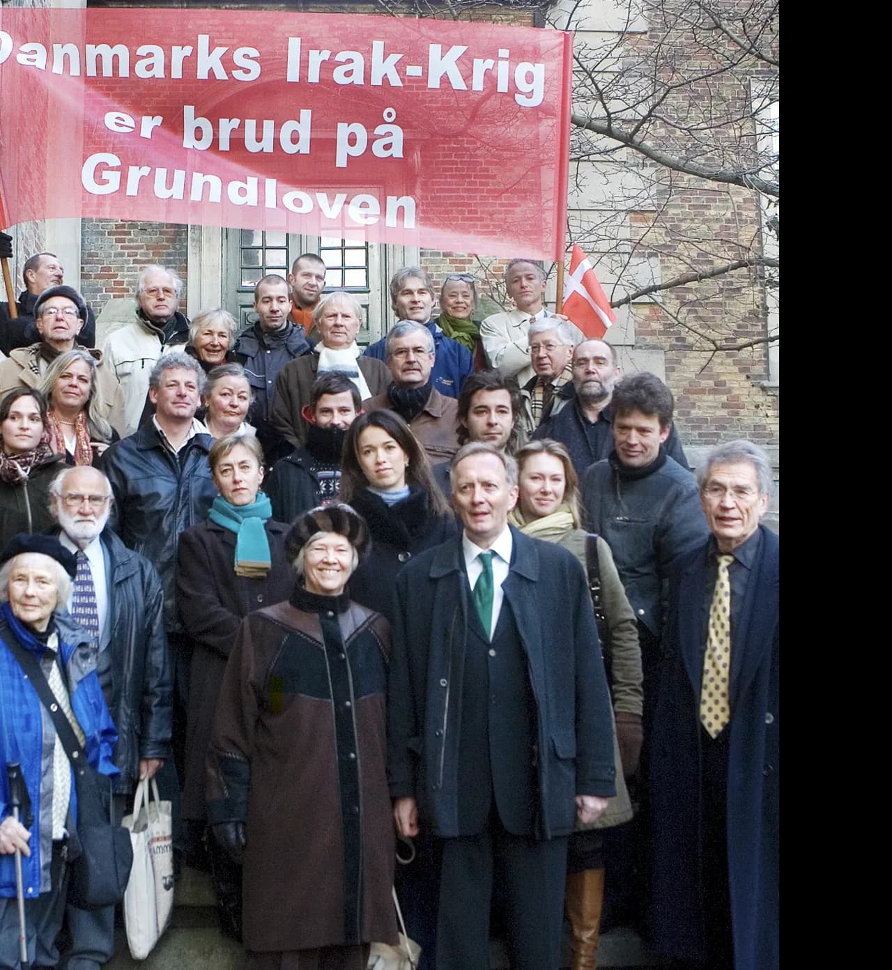 Advokat Bjørn Elmquist og Christian Harlang står sammen med 23 bekymrede borgere som sagsøgere m.fl. ved foden af trappen til Østre Landsret (Bredgade). Billedet er taget på dagen for hovedforhandlingens påbegyndelse i førsteinstans.