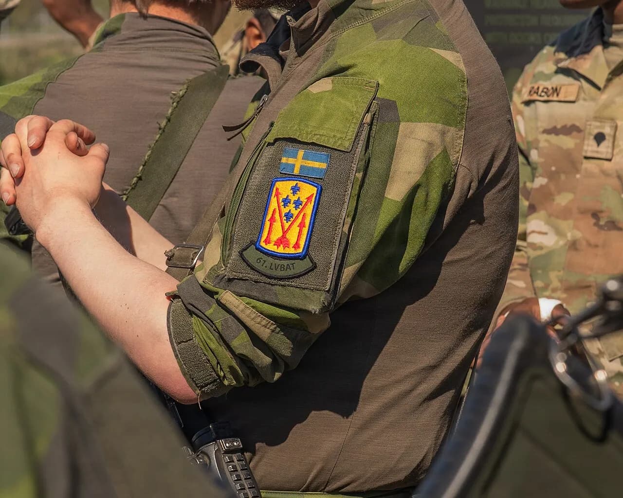 En svensk soldat bærer en brigadepatch under en statisk fremvisning i forbindelse med øvelsen SWORD 26. Billedet viser træning og samarbejde omkring luftforsvarskapaciteter.