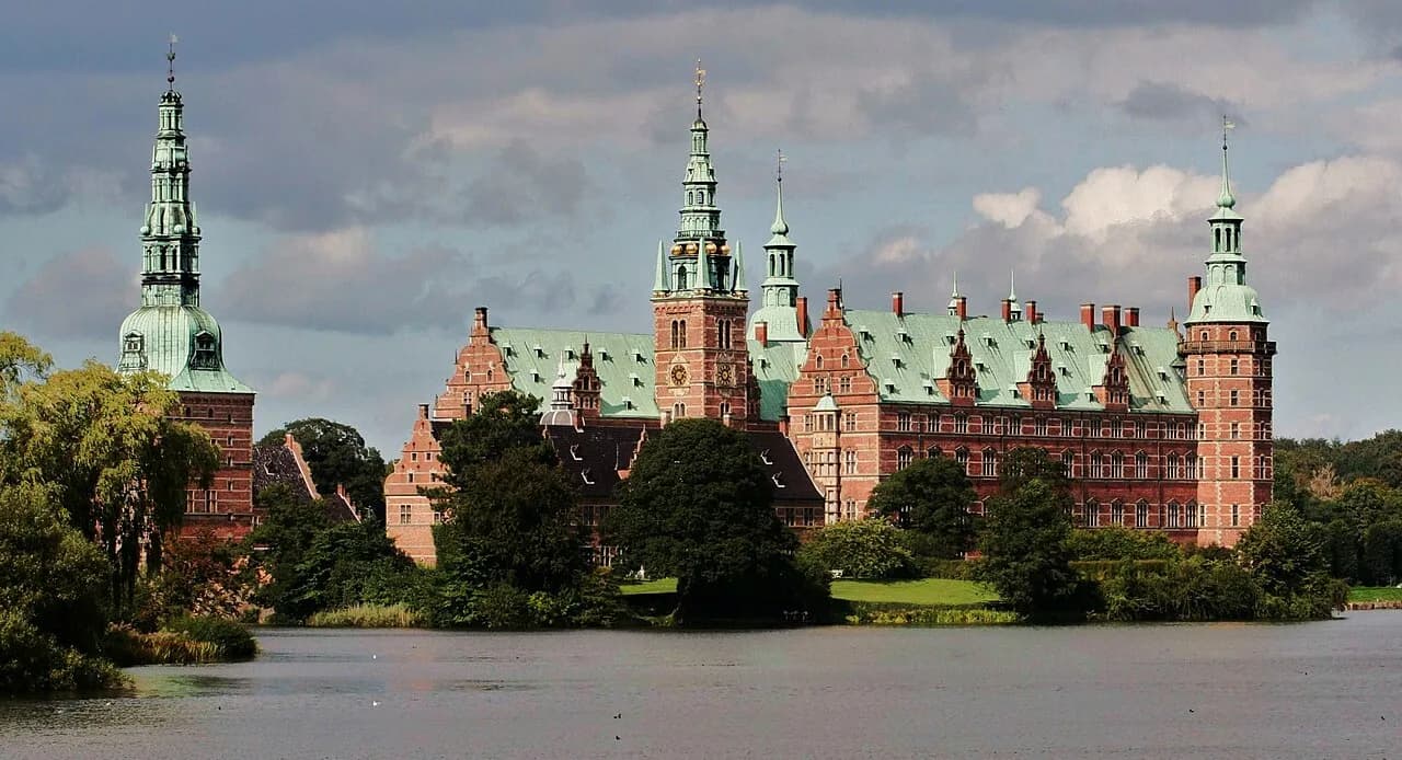 Frederiksborg Slot ses i solskin med tydelige detaljer i facaden. Et stemningsfuldt motiv fra Frederiksborg Slot i Danmark.