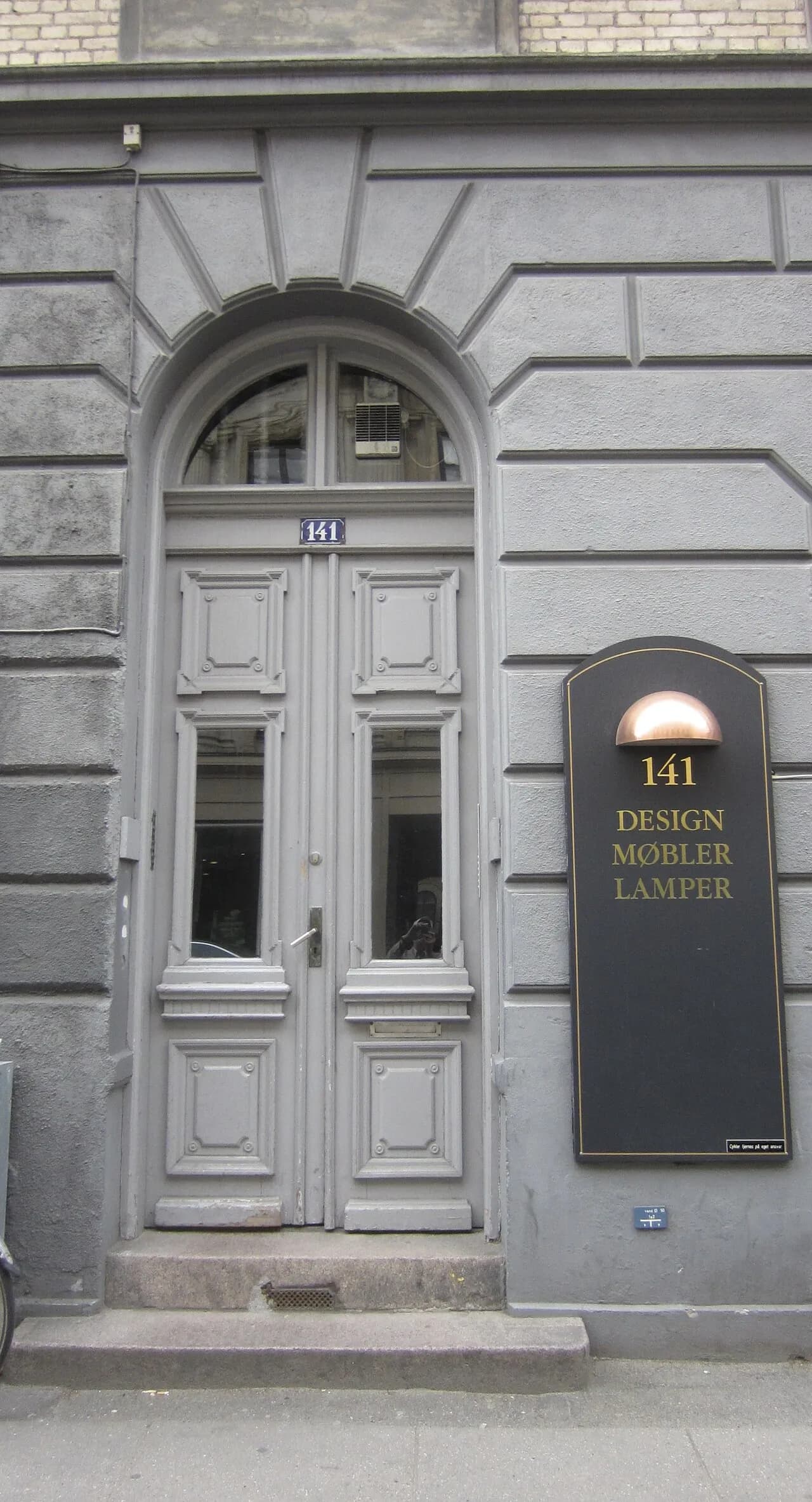 Bygningen på Gammel Kongevej 141 i København ses her i et historisk bymiljø. Et detaljepræget facadebillede med tydelig arkitektonisk karakter.