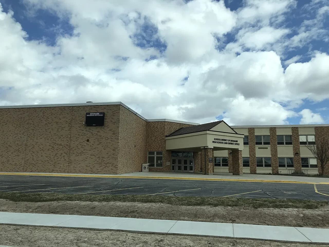 Fotografi af hovedindgangen til Denmark High School i Denmark, Wisconsin. Billedet viser skolens facade og indgangsområde.