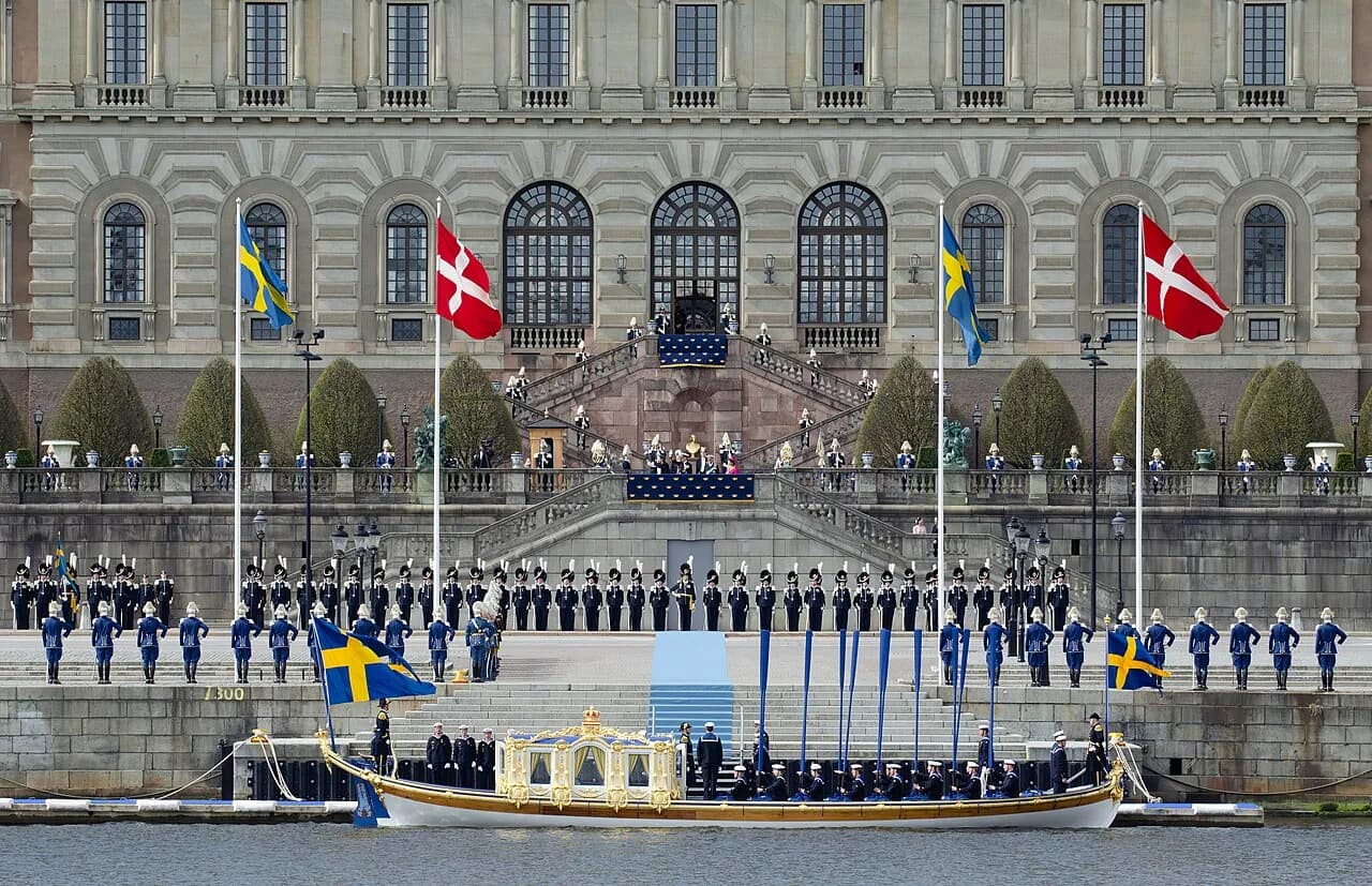 Kong Frederik X og Dronning Mary ankommer til Sverige med Den Kongelige Vasaorden og modtages ved Stockholms slot. Billedet viser ankomsten over Salt Lake og modtagelsen ved Logård-trappen.