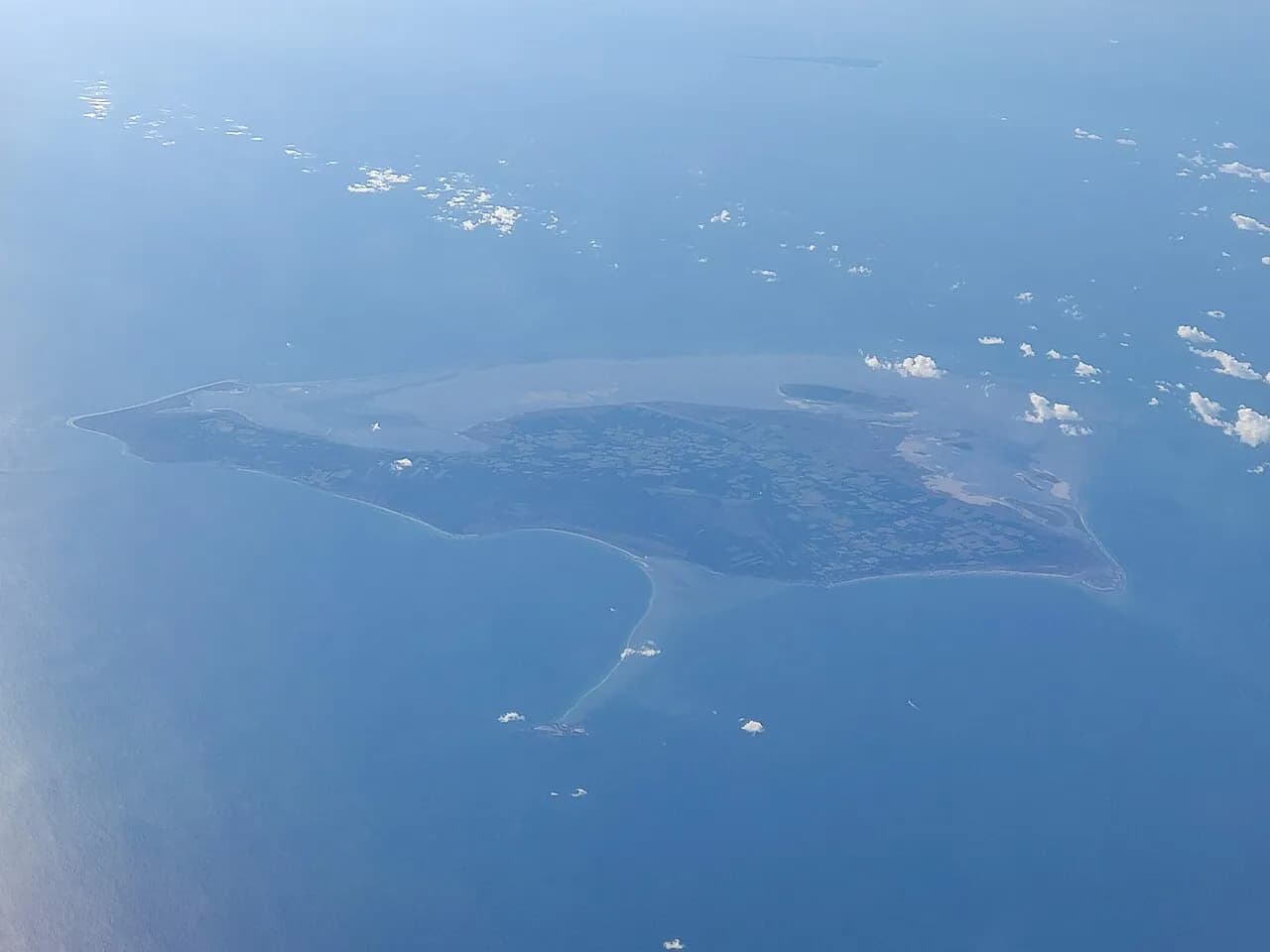 Luftfoto af Læsø, Danmark, taget fra nordvest. Perspektivet fremhæver øens landskab og kystlinje.