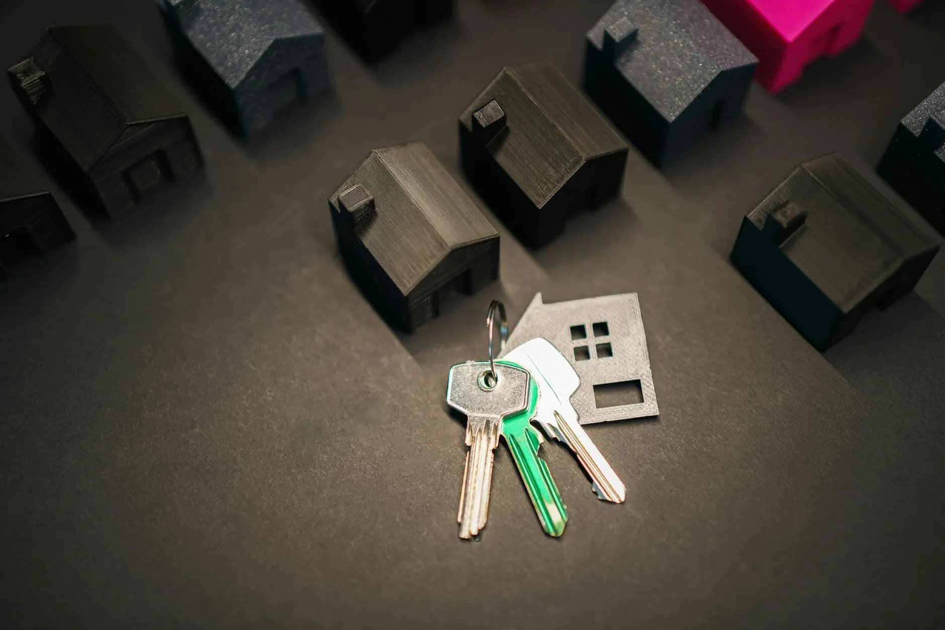 Miniature husmodeller og nøgler illustrerer investering i fast ejendom og boligmarkedet. Billedet signalerer ejerskab, værdi og fremtidige muligheder.