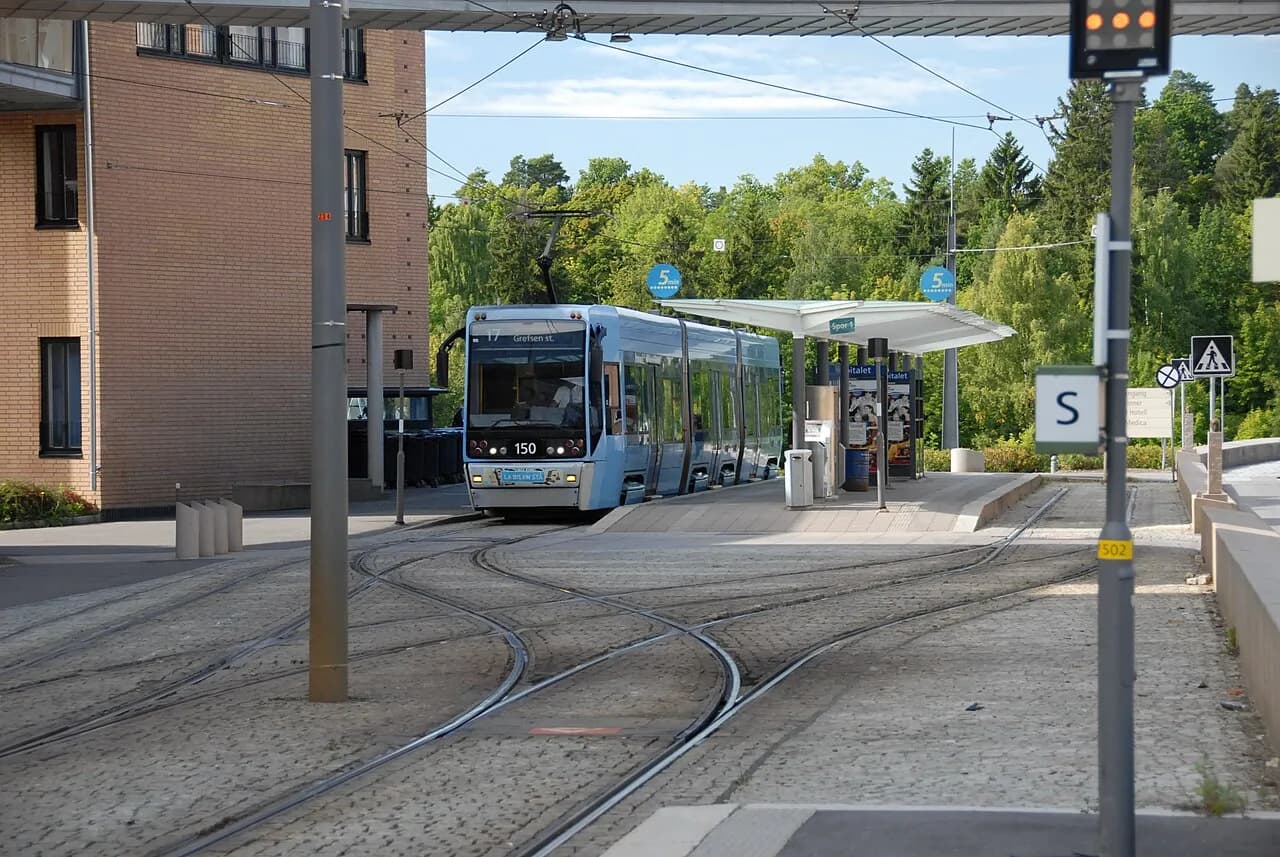 Rikshospitalet-stationen i Oslo ses med en SL-95 sporvogn. Billedet viser byens offentlige transport i et bynært miljø.