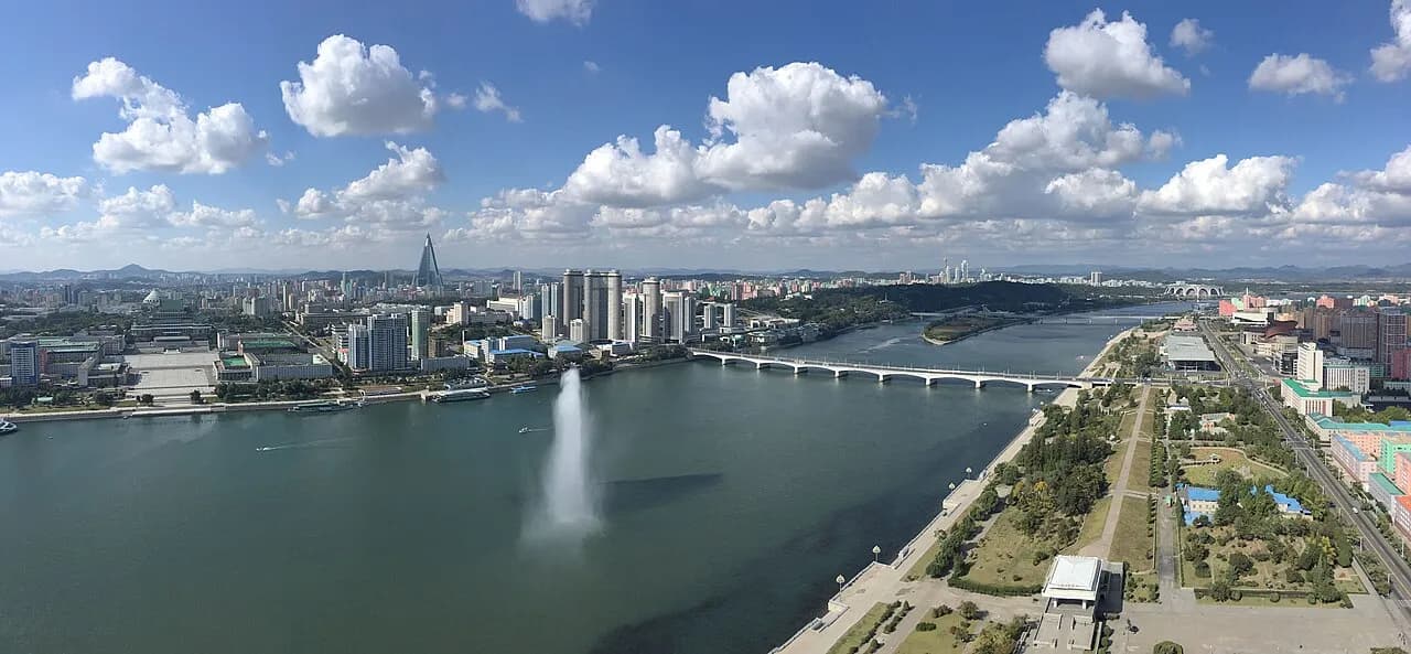 En panoramaudsigt over Pyongyang set fra Juche-tårnet. Billedet viser byens skyline og landskabet omkring.