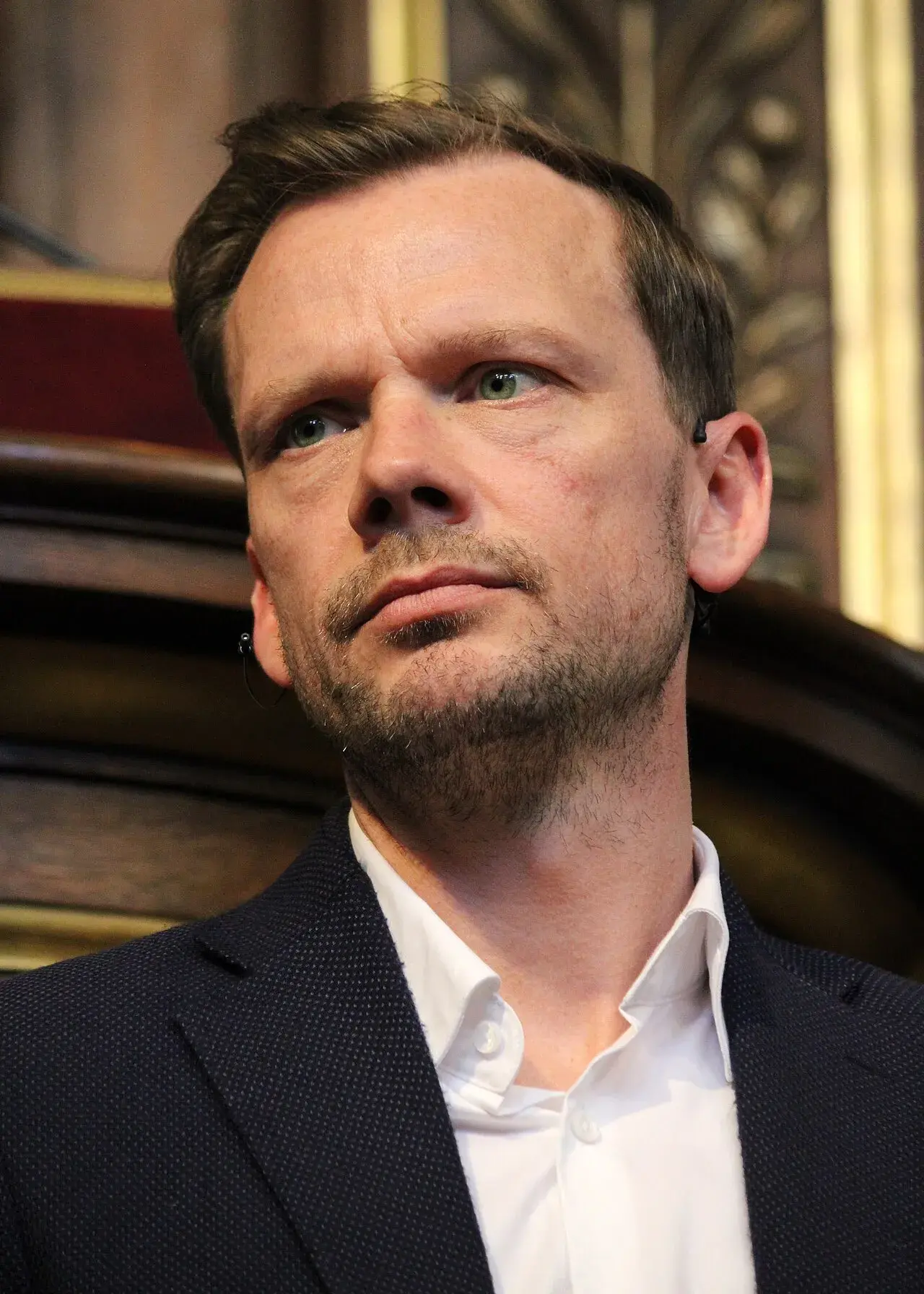 Peter Hummelgaard taler til publikum under en politisk debat i Festsalen på Københavns Universitet. Fotoet er taget under en begivenhed i København.