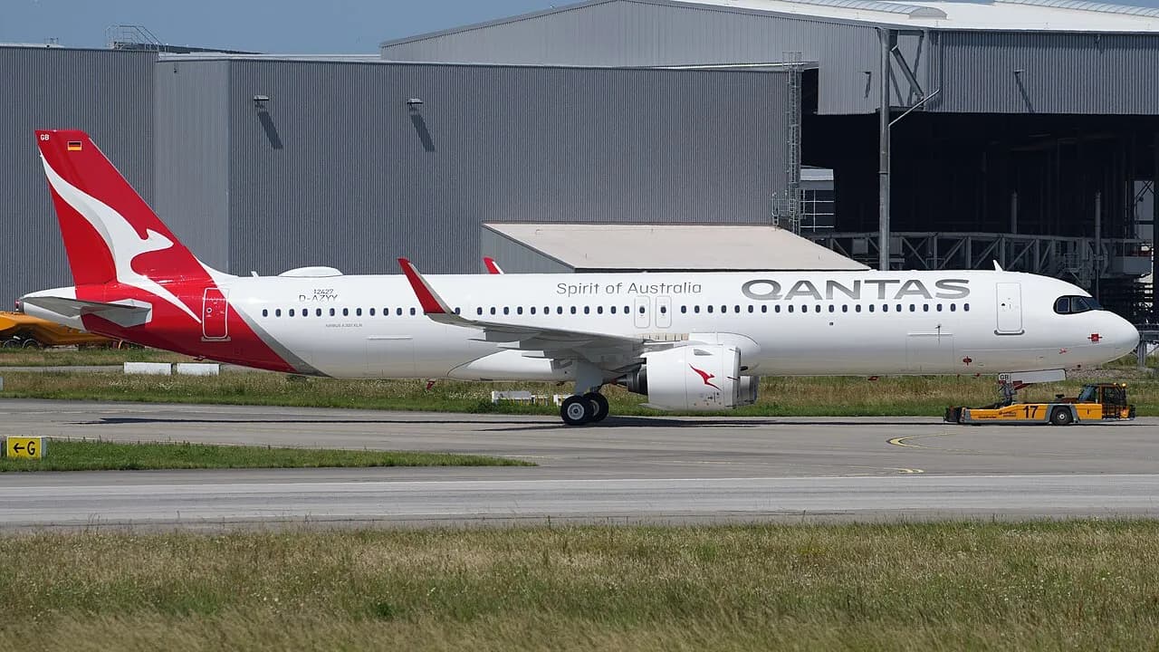 En Qantas Airways Airbus A321-271NY XLR med registrering VH-OGB bliver bugseret over flyvepladsen ved Hamburg-Finkenwerder. Billedet viser flyet i forbindelse med ground handling.