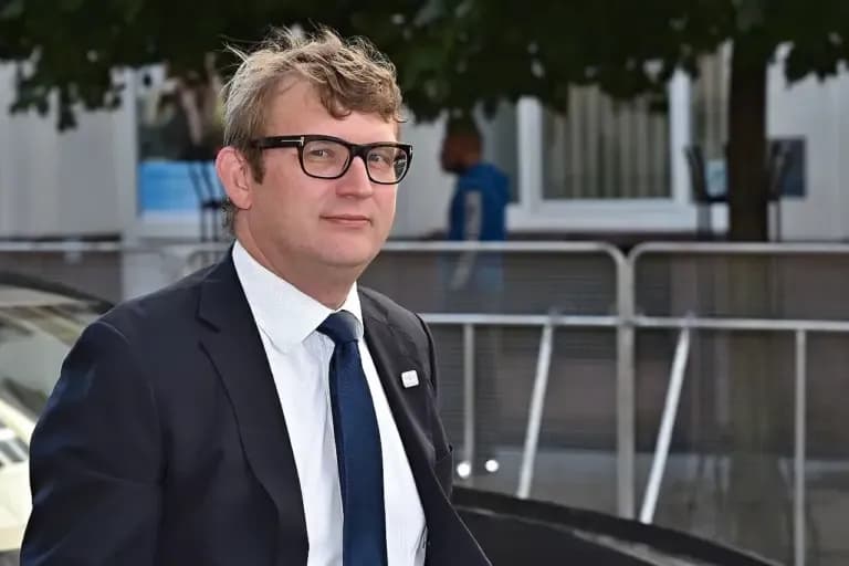 En gruppe forskellige personer står samlet og selvsikkert foran et amerikansk flag ved et valgpodium. Billedet signalerer politisk engagement og demokrati.
