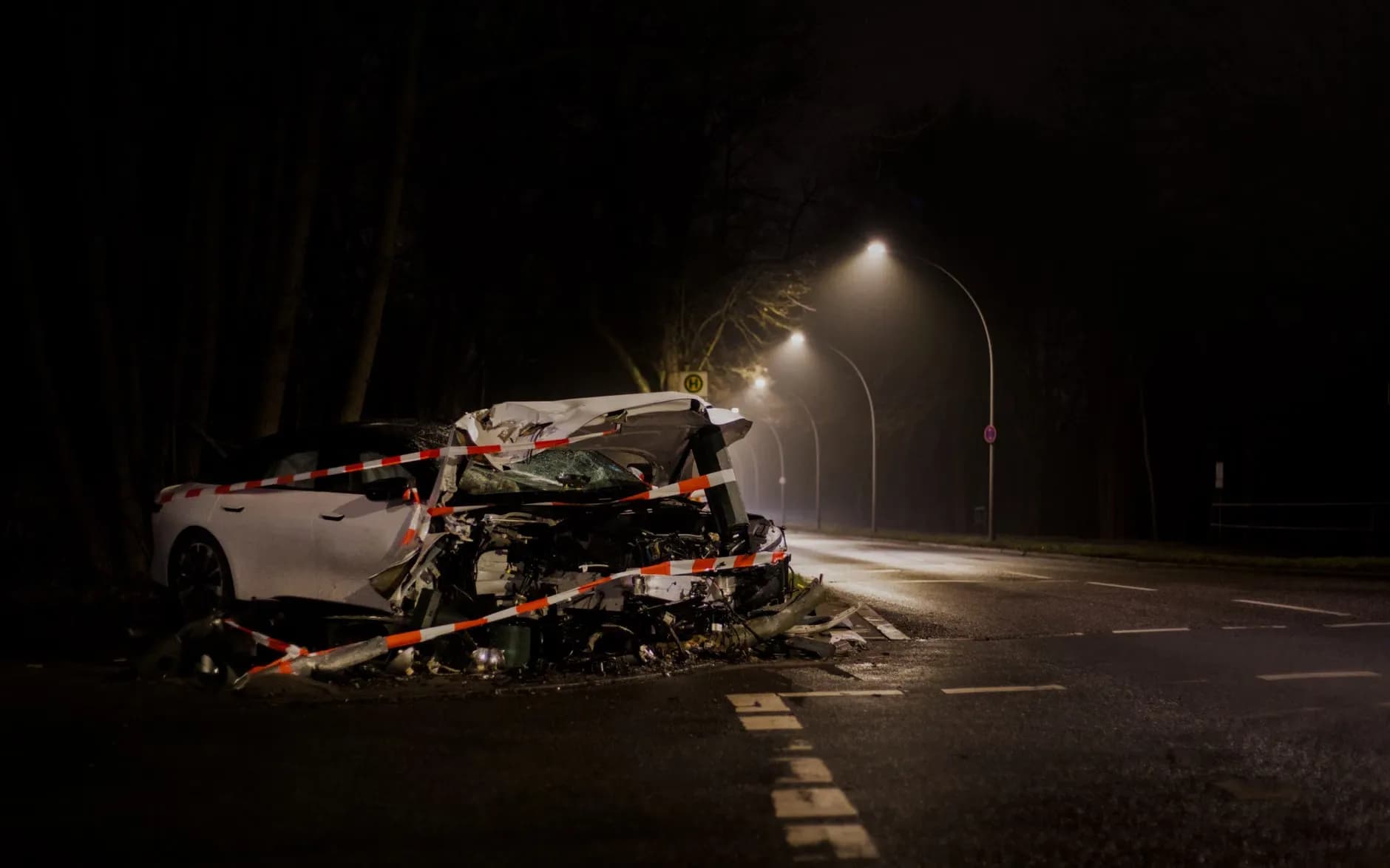 En rød bil er væltet over på en sort bil i en udendørs scene. Billedet viser et dramatisk øjeblik fra en bilkrasch.