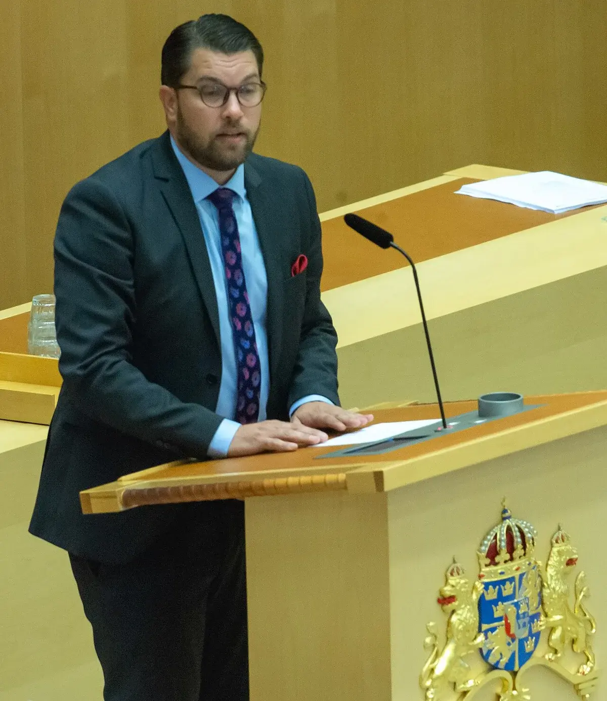 Jimmie Åkesson speaking at a lectern in the Swedish parliament.