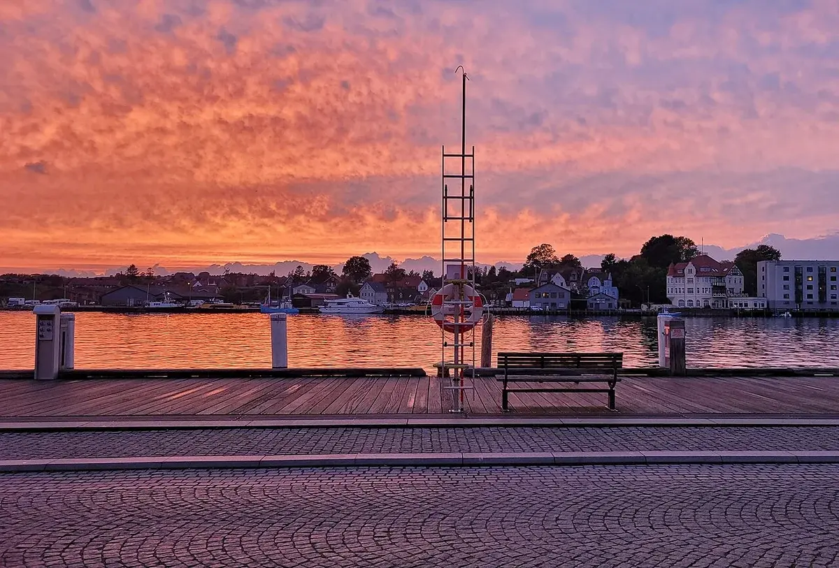 Sunset over Sønderborg harbor with colorful clouds and waterfront promenade