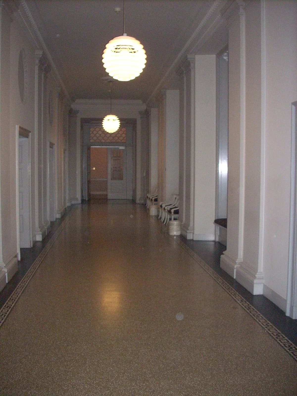 long corridor with hanging lamps and chairs