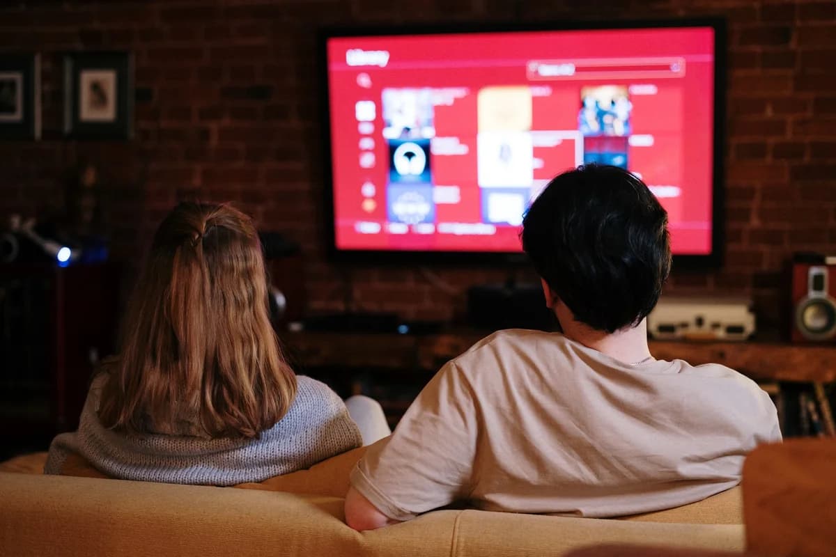 Couple watching streaming shows on TV in a brick-walled living room
