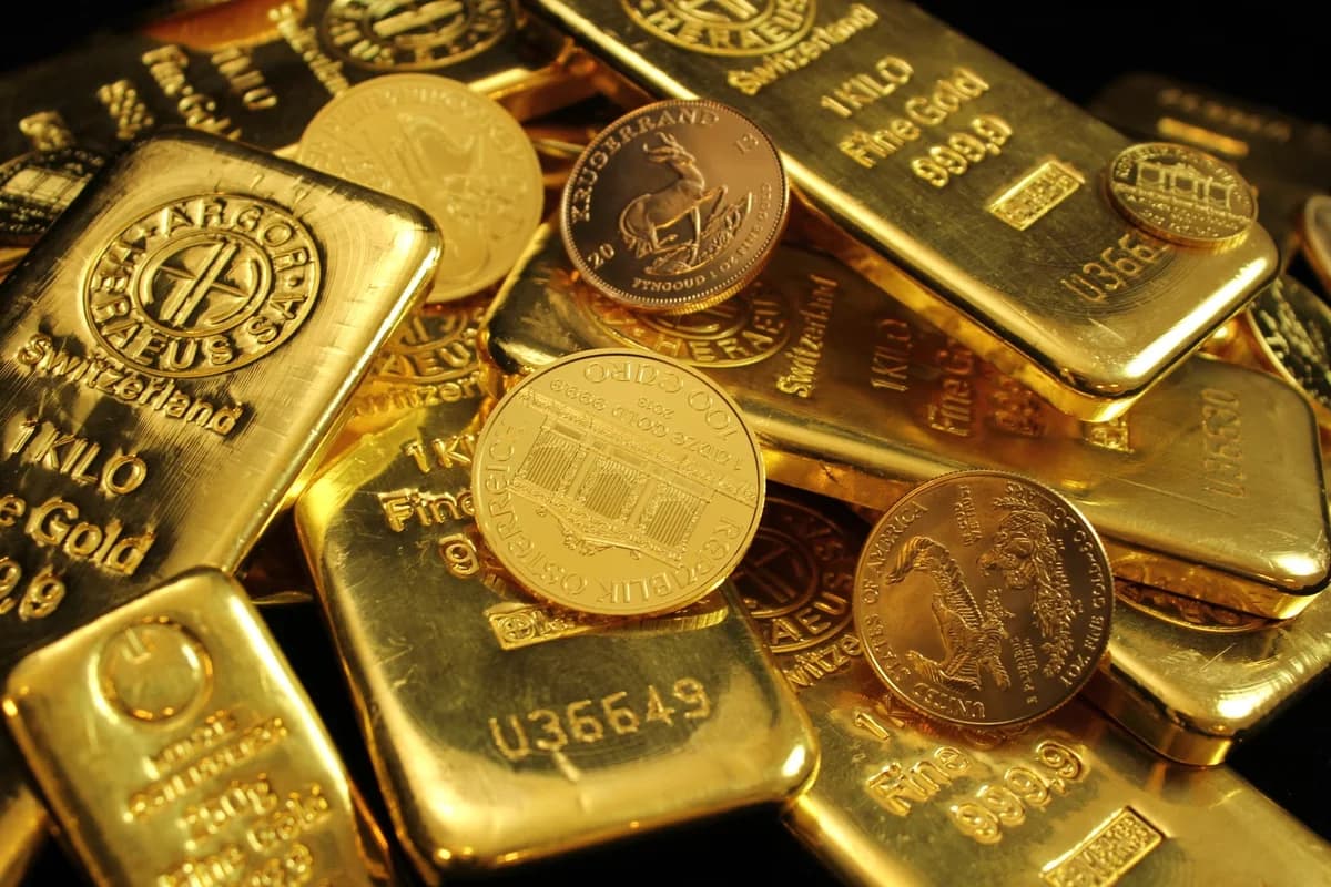 Close-up of gold bars and coins stacked together.