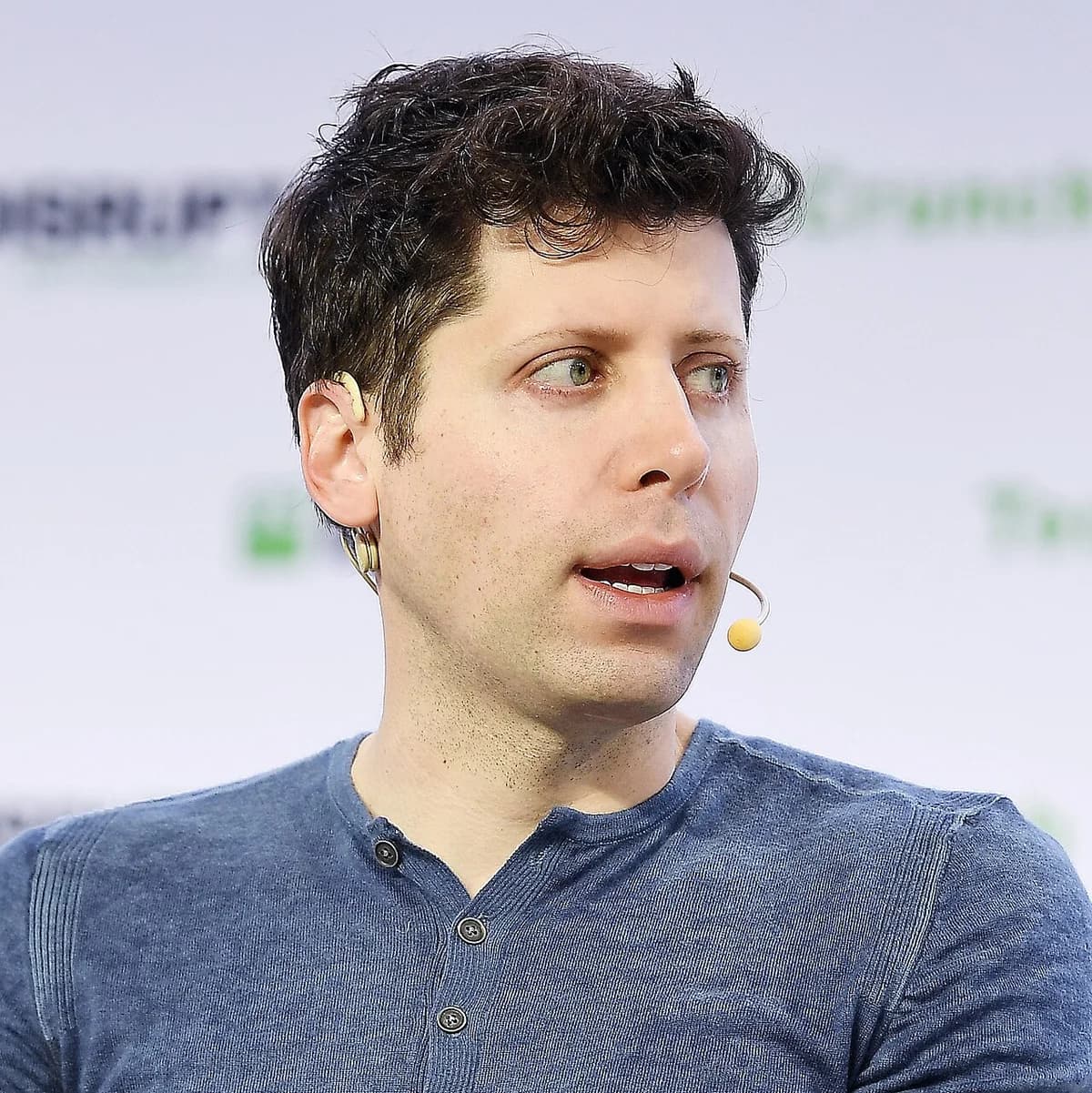 Sam Altman speaking on stage at a conference.