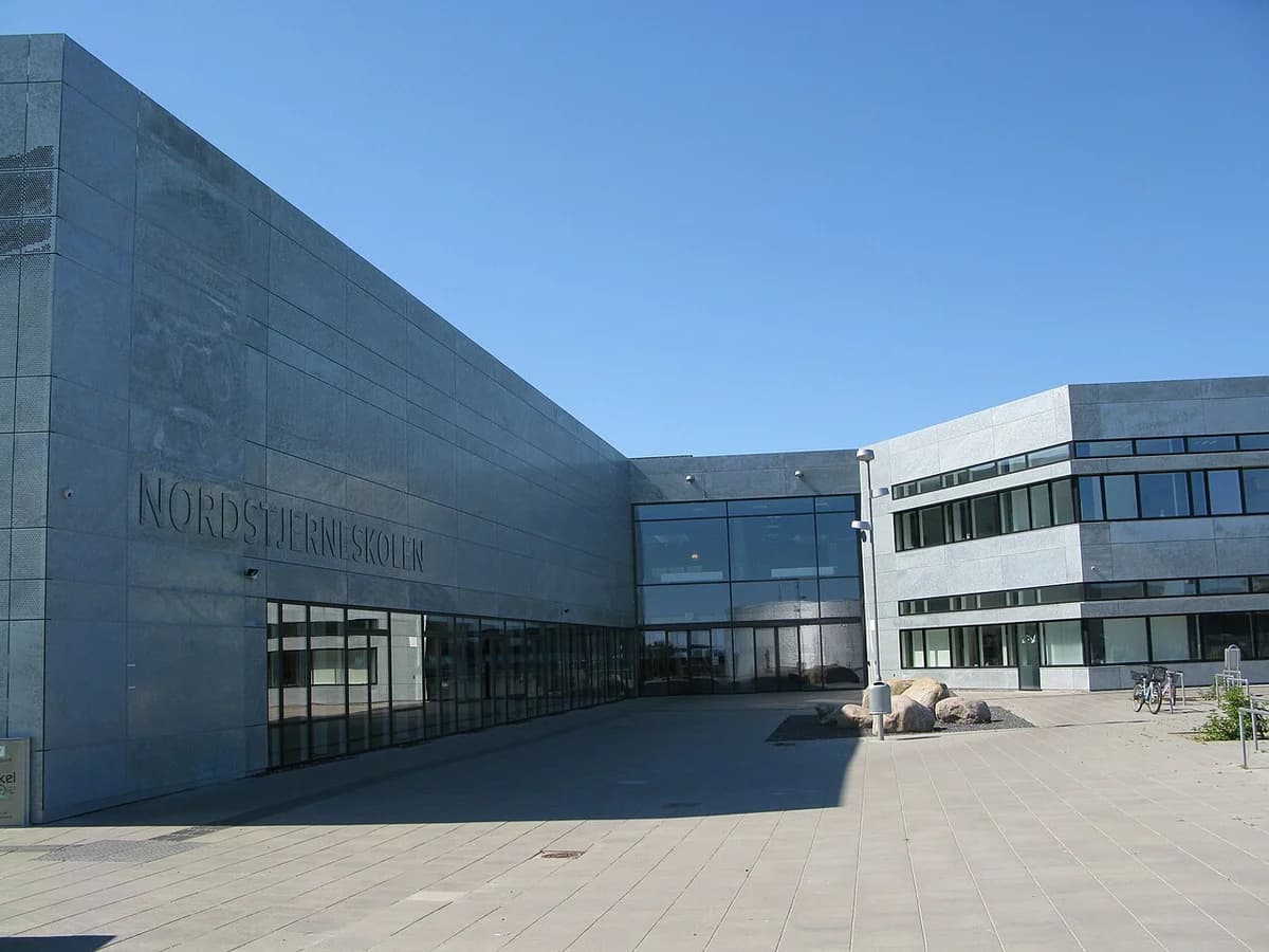Modern school building facade with the name Nordstjerneskolen on the wall.