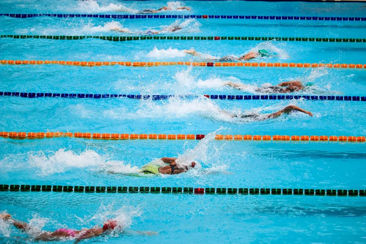Swimmers racing in an outdoor pool