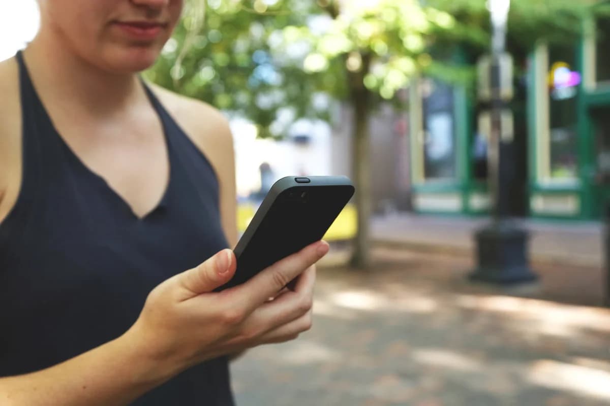 Close-up of a young woman using a smartphone outdoors.