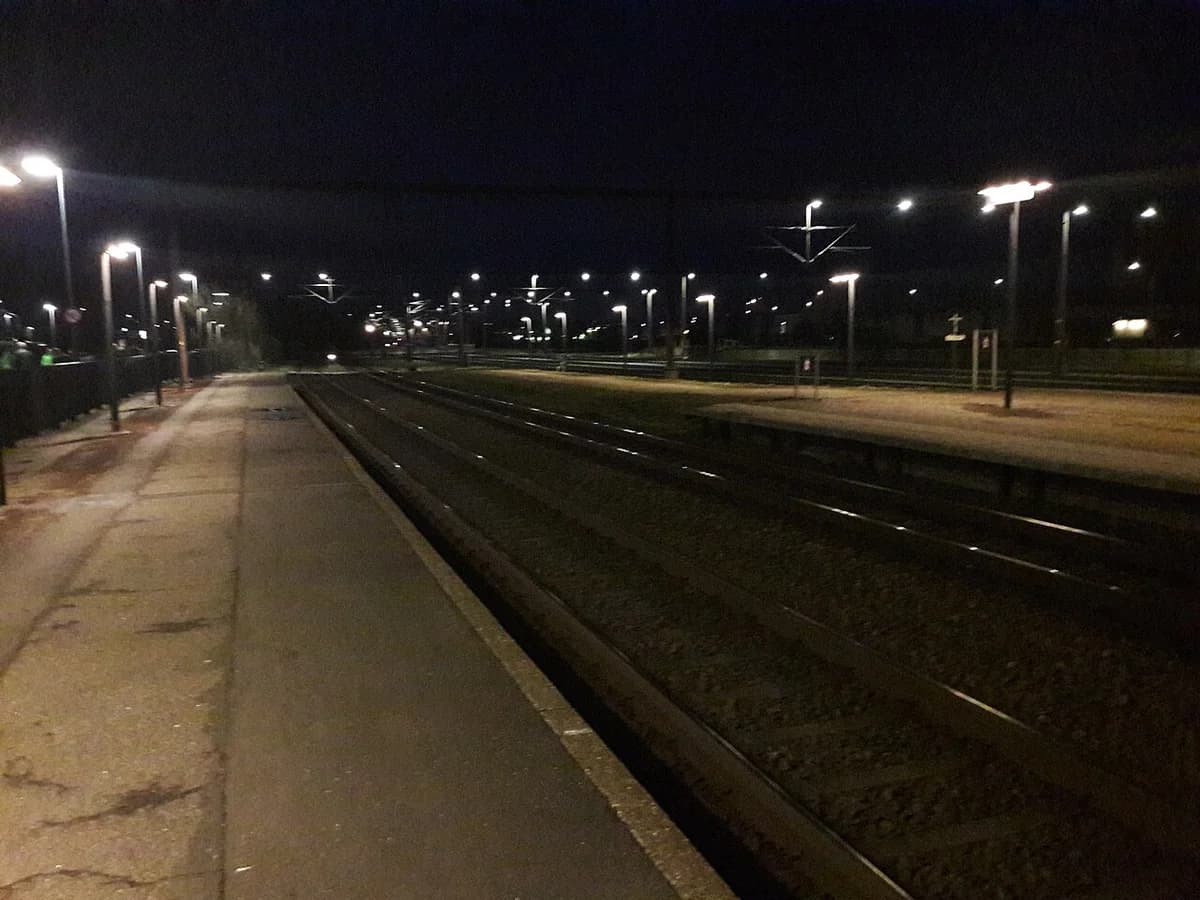 Night view of a railway platform and tracks in Kolding, Denmark.