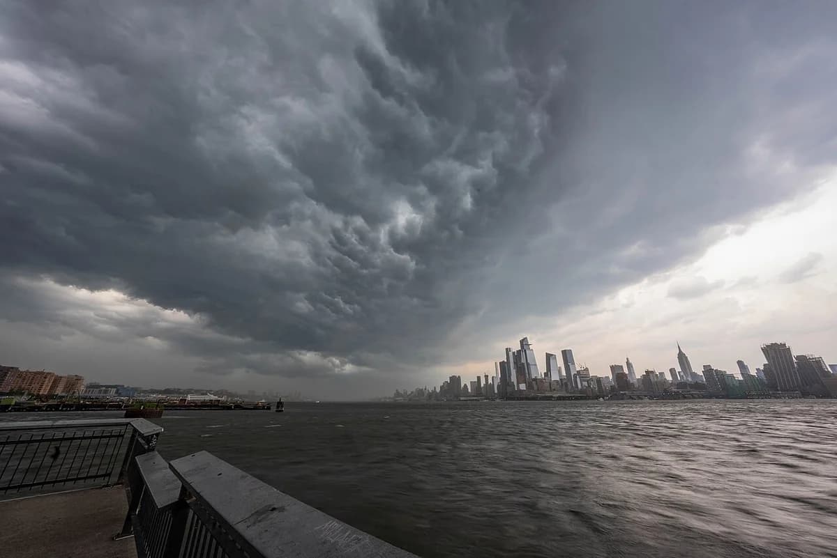 Dark storm clouds over the New York City skyline and water.