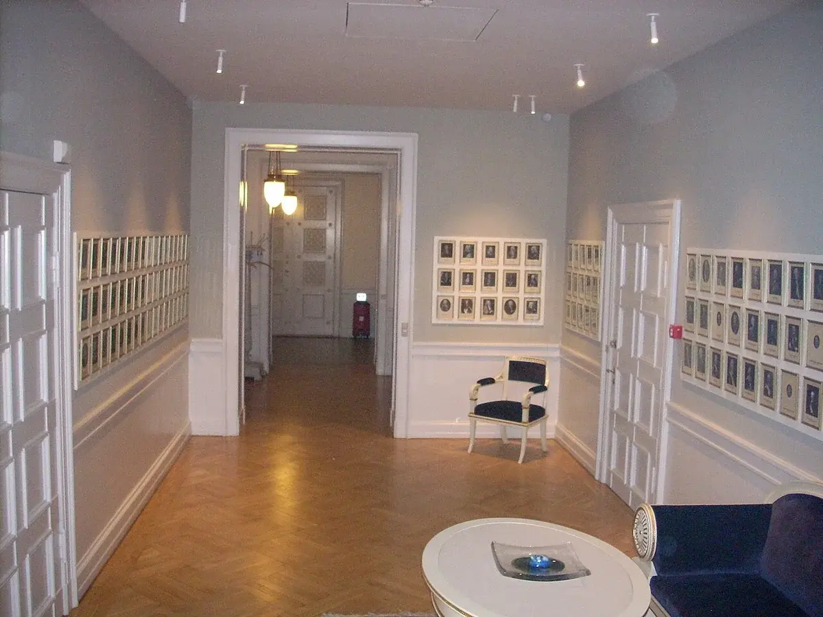 Hallway gallery with framed portraits on both walls.