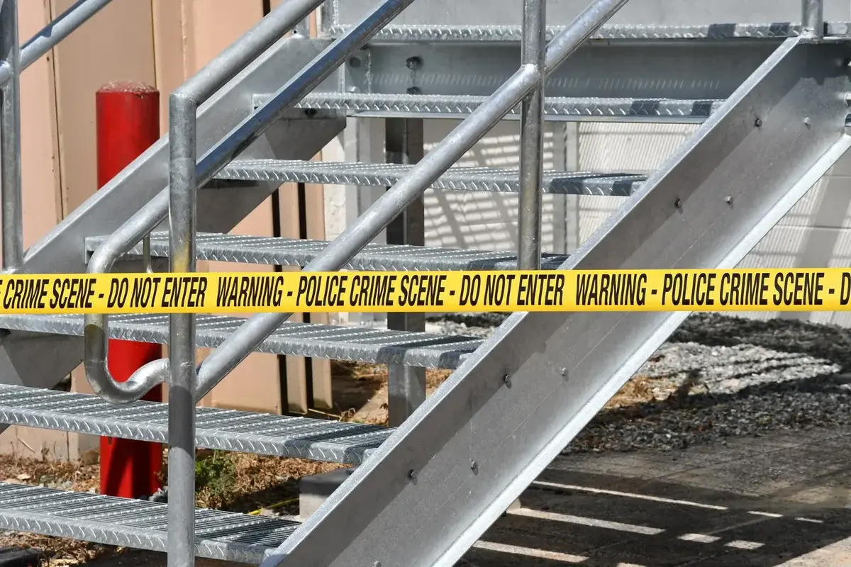 Metal staircase blocked by yellow police crime scene tape