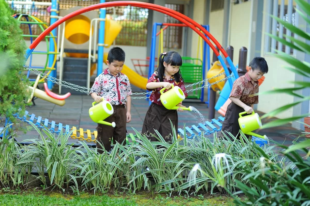 Children watering plants in a playground garden