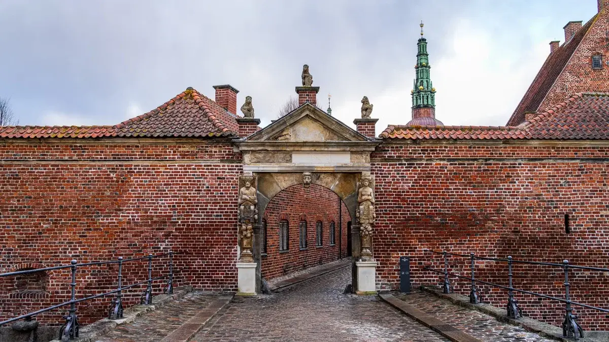 Brick gatehouse at Frederiksborg Castle with an arched entrance.