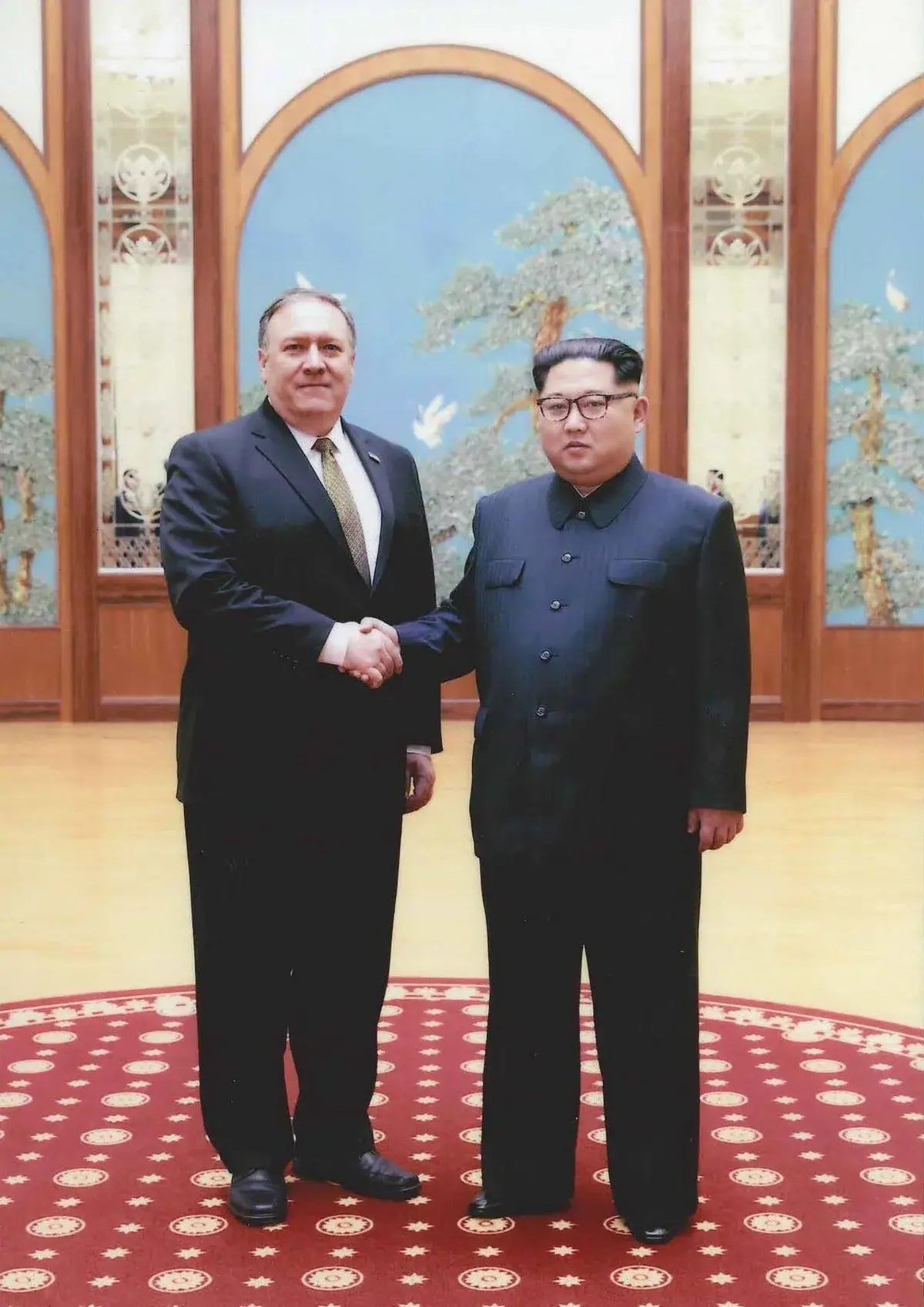 Mike Pompeo shaking hands with Kim Jong-un in an ornate room.