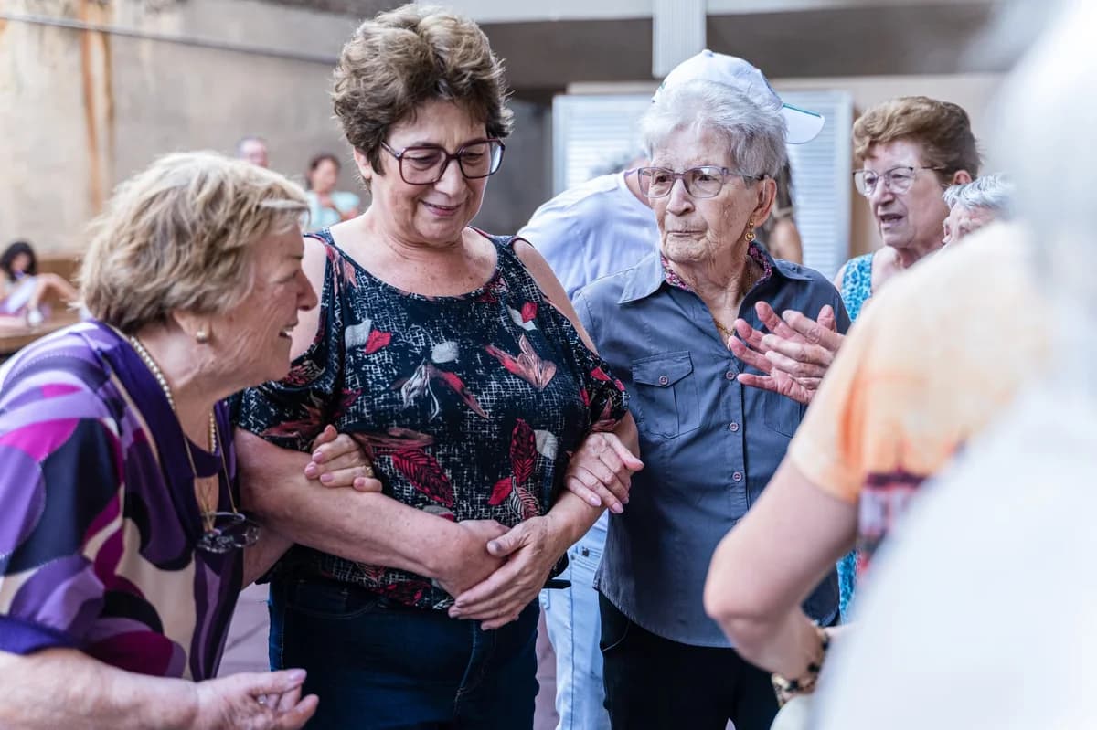 Elderly women socializing outdoors, holding hands