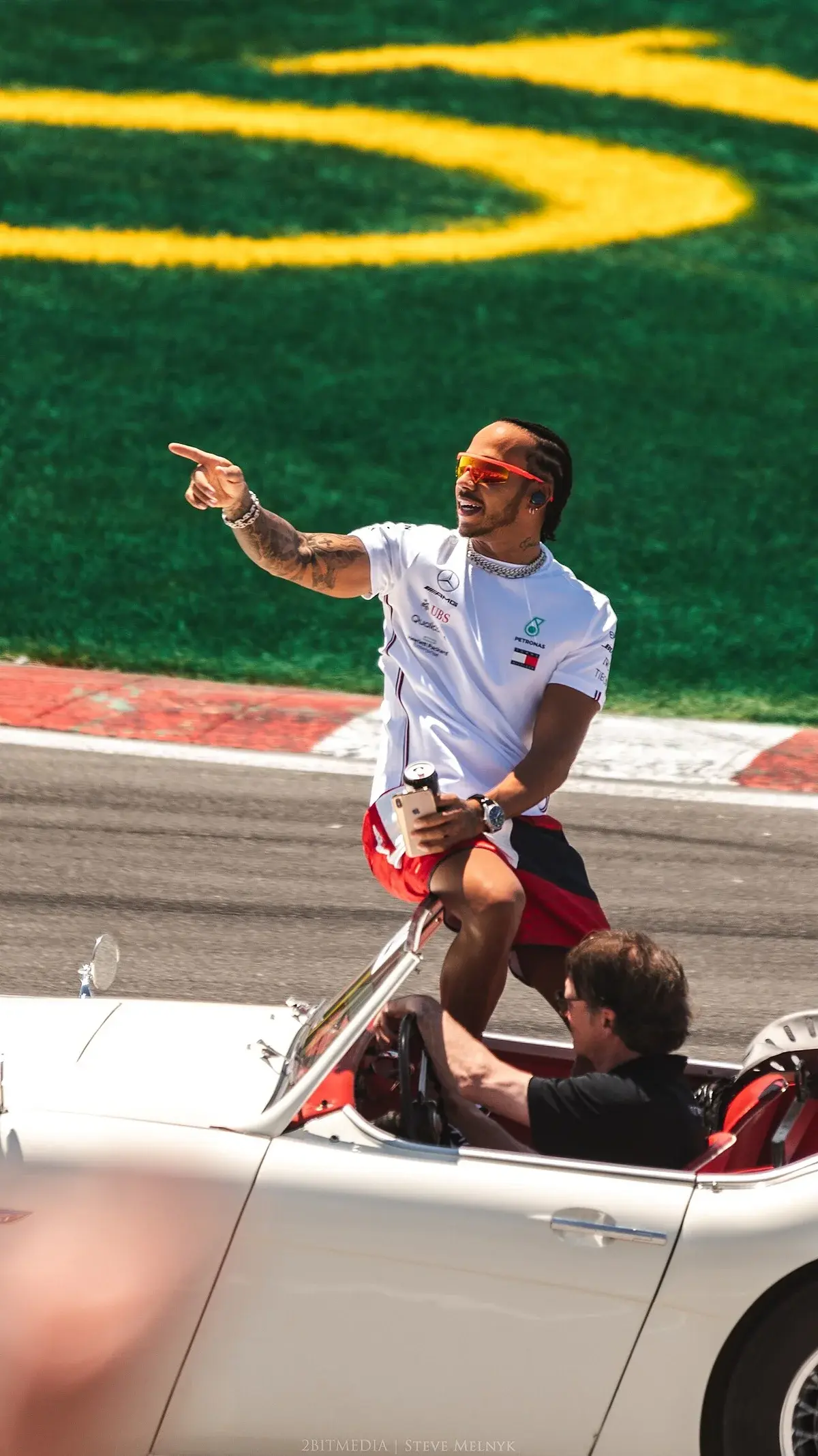 Lewis Hamilton riding in a classic convertible and pointing toward the crowd at the Canadian Grand Prix.