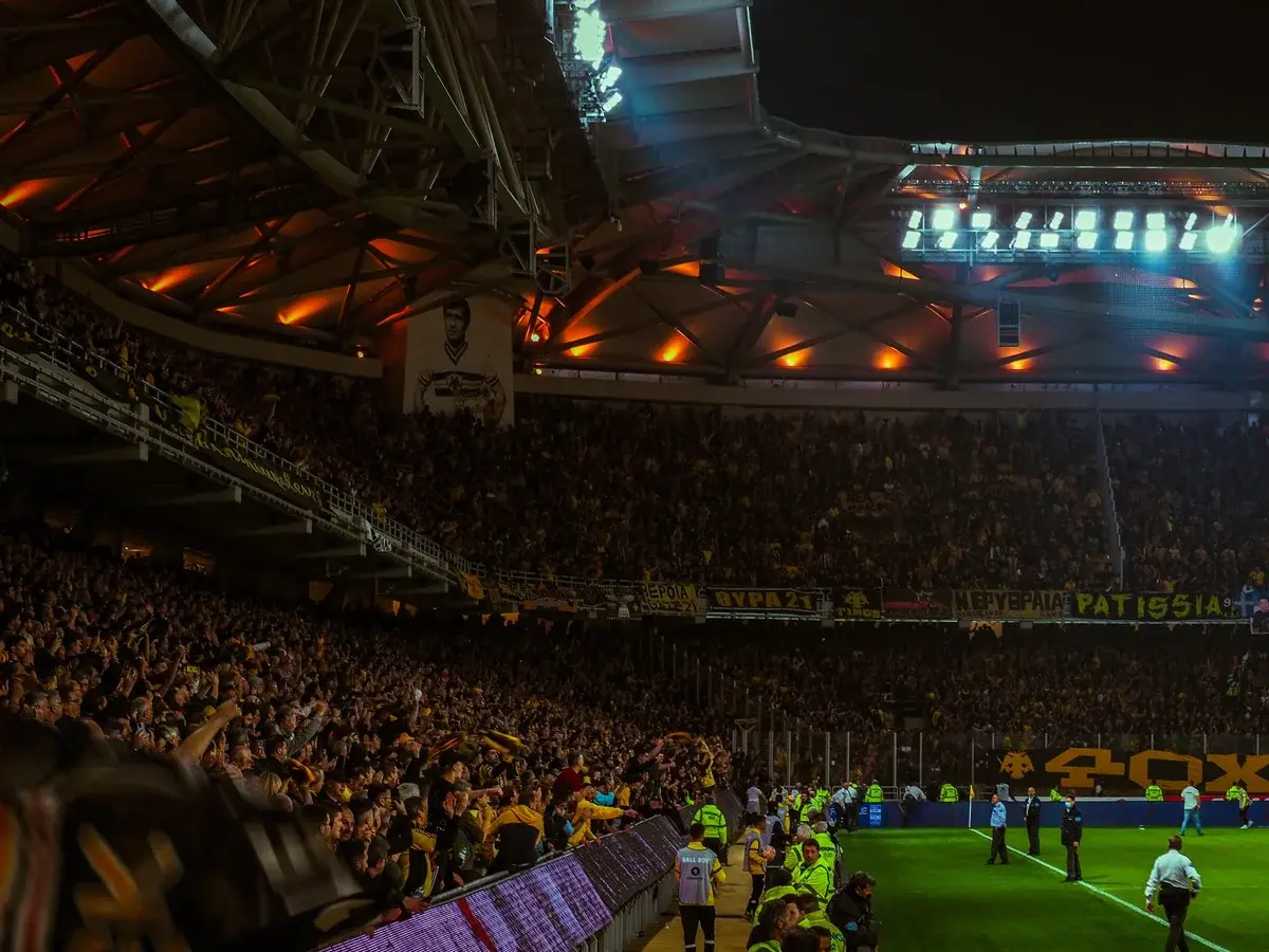 Packed football stadium at night with cheering fans and bright lights