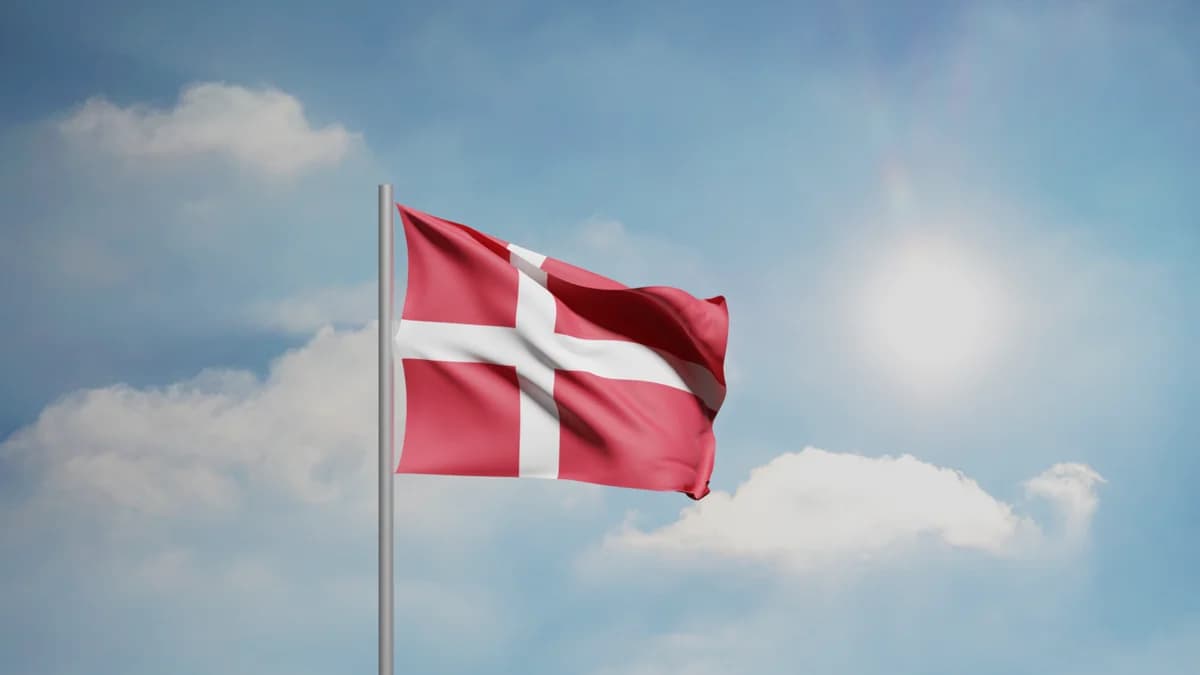 The Danish flag waving against a sunny blue sky.