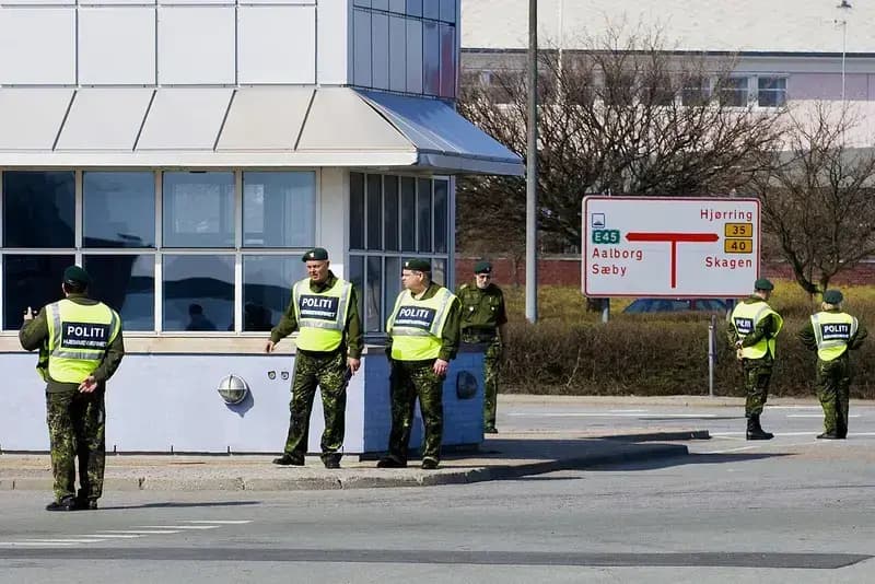 Danish police and Home Guard in uniform at a street corner with directional road signs