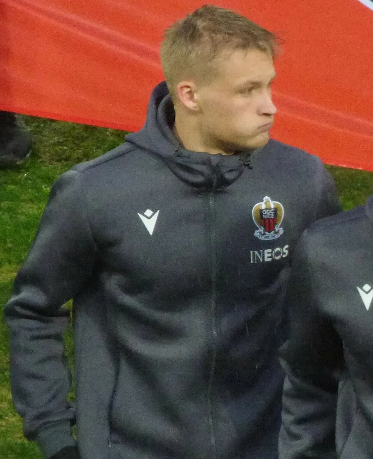 Kasper Dolberg in an OGC Nice hoodie at a football match.