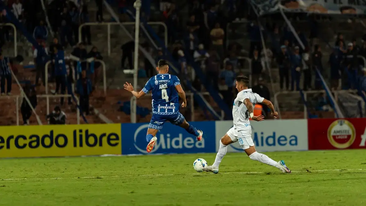 Two soccer players contesting for the ball on the field