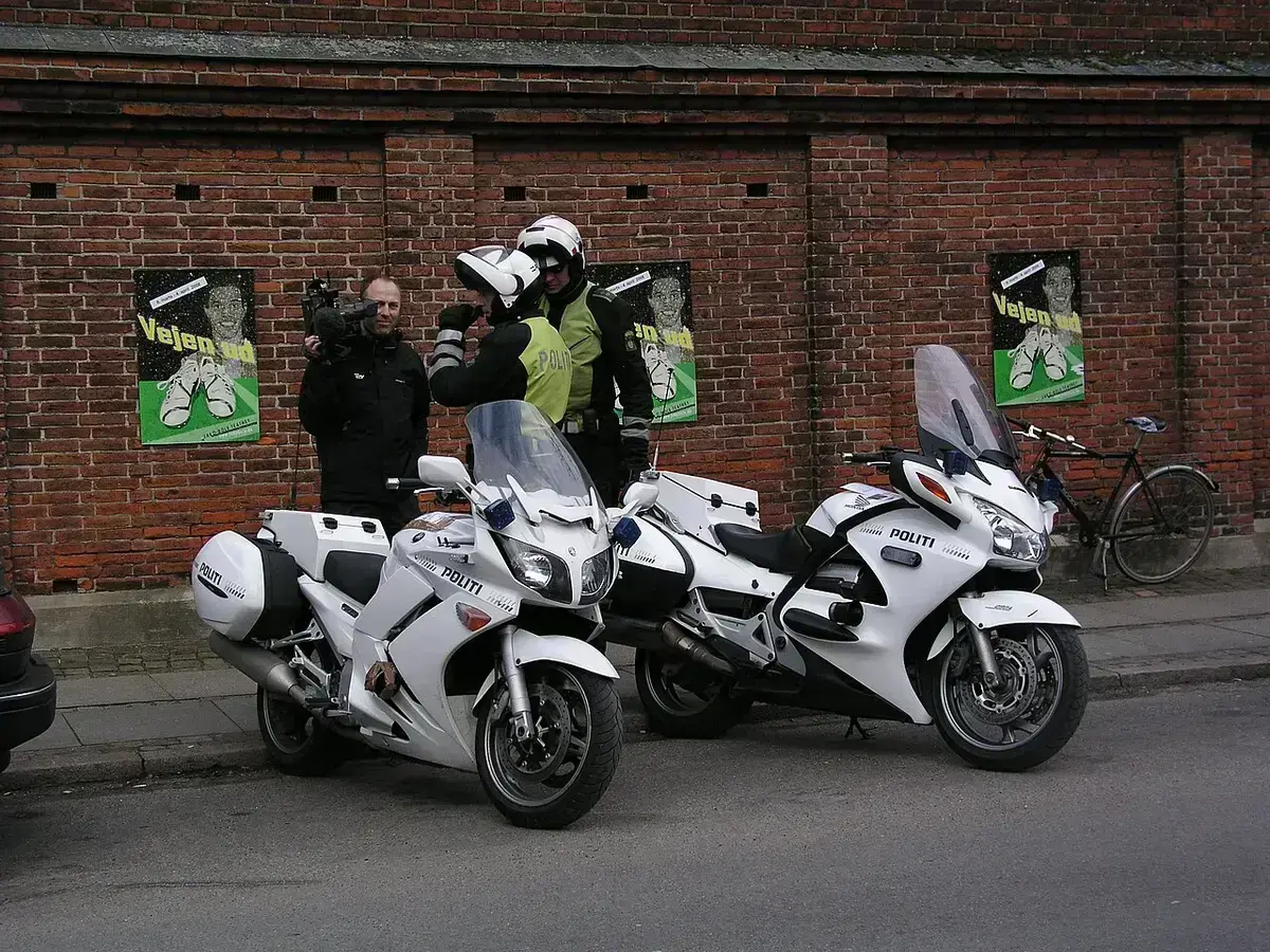 Two Danish police officers with white motorbikes on a street