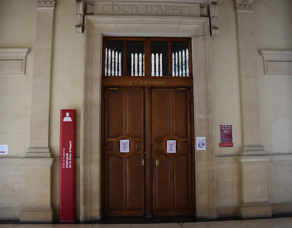 A formal wooden courtroom entrance inside the Palais de Justice in Paris.