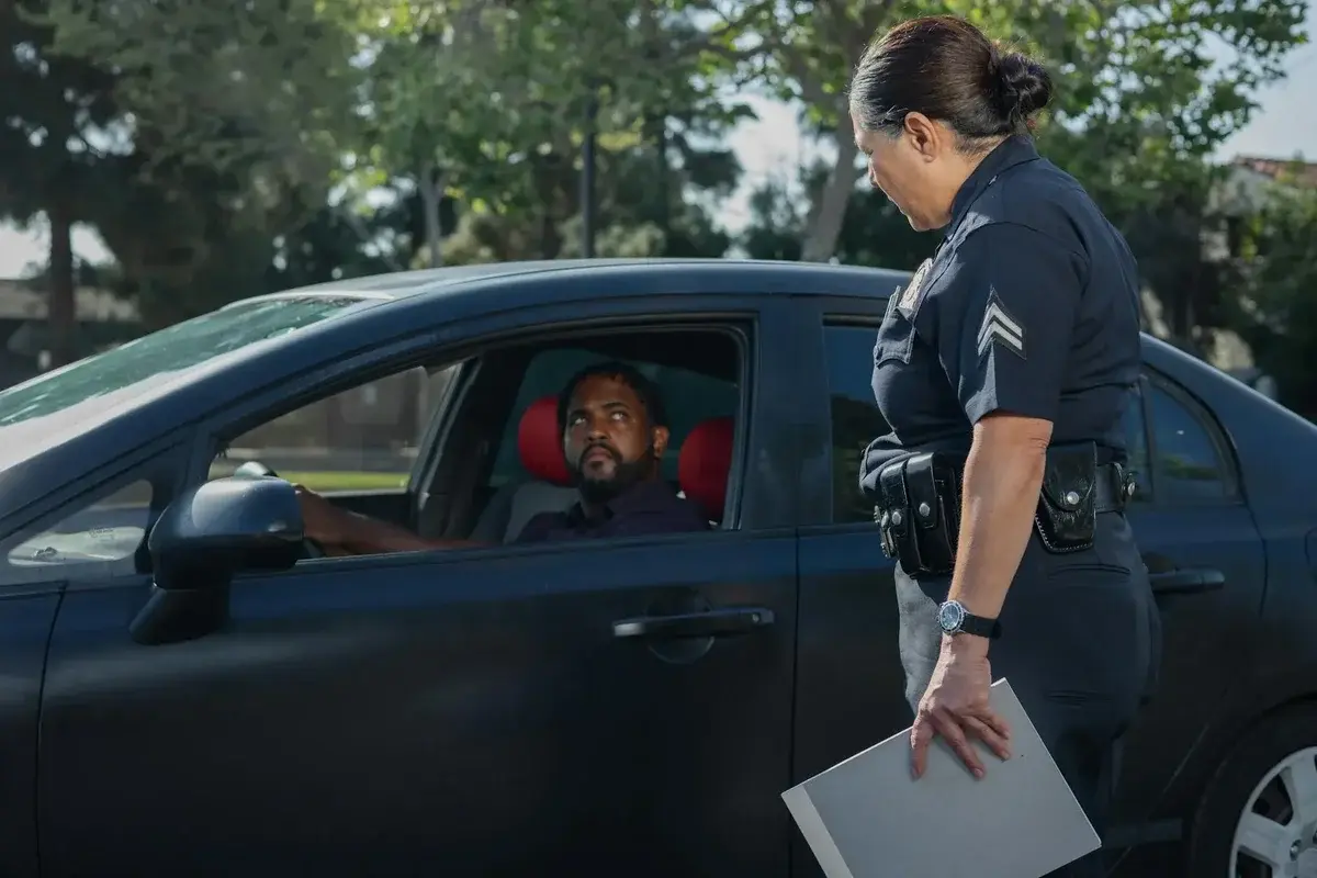Police officer talking to driver beside car