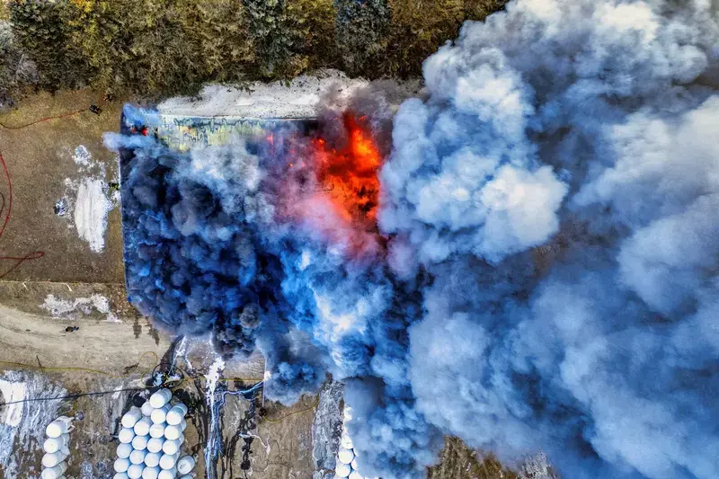 Aerial shot of burning building emitting thick smoke