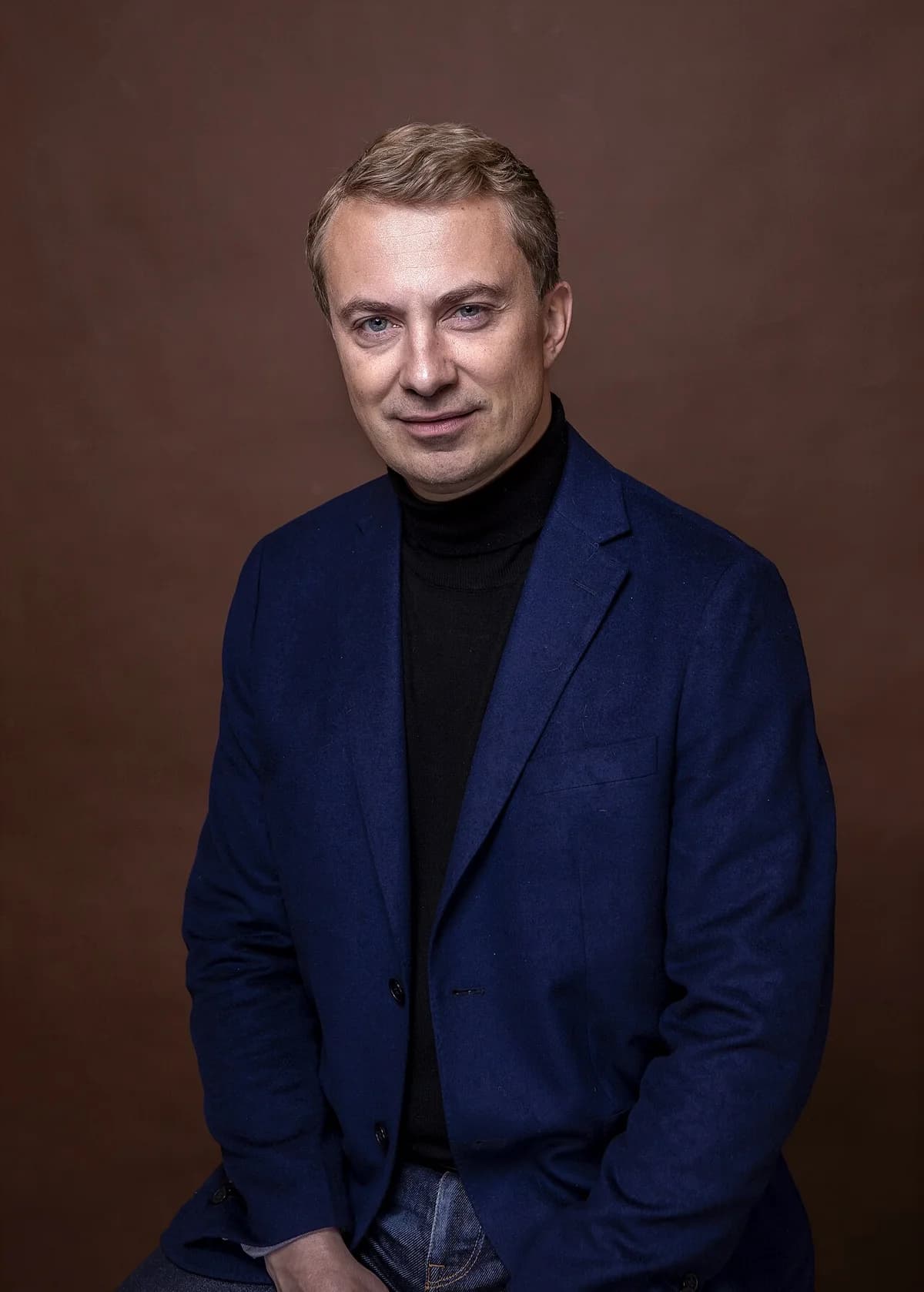 Formal portrait of Morten Messerschmidt in blue blazer and black turtleneck