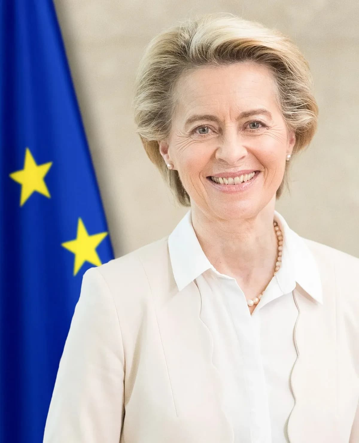 Portrait of Ursula von der Leyen in front of the European Union flag.