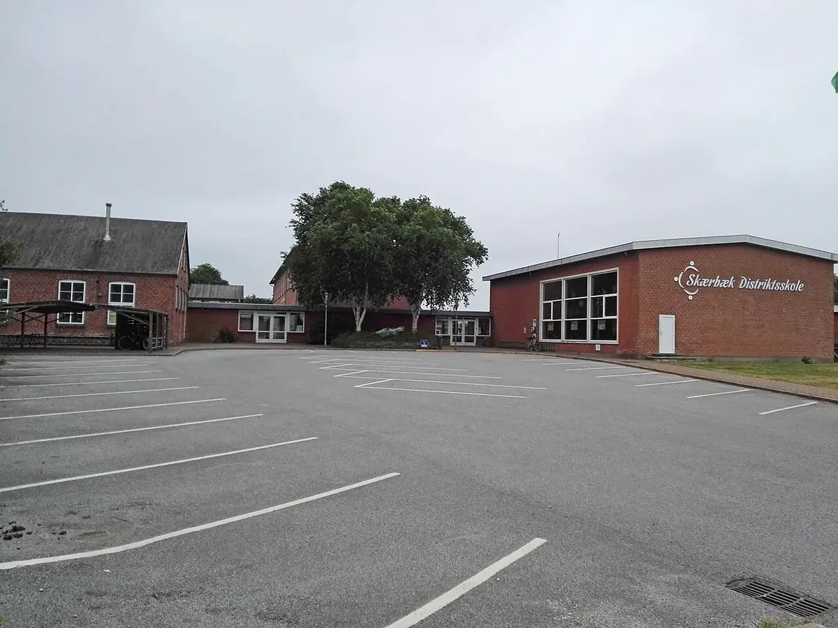 Exterior of Skærbæk District School with buildings and a parking lot.